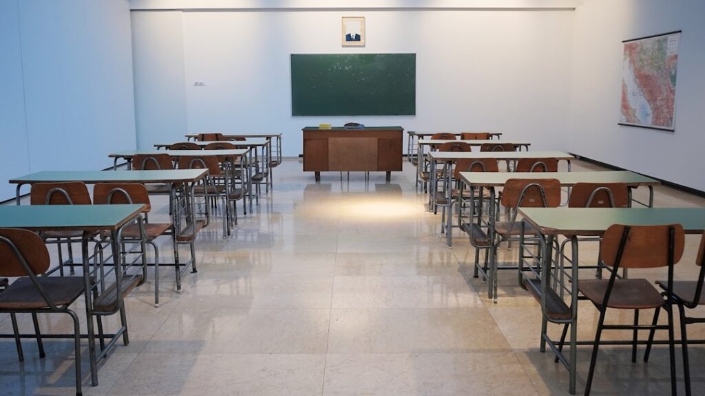 Jasna sala szkolna z rzędami ławek