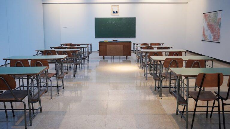 Jasna sala szkolna z rzędami ławek